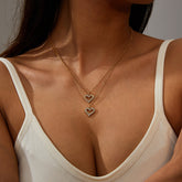 Elegant gold heart pendants with diamond accents, showcasing a layered necklace design in 18K gold plating.